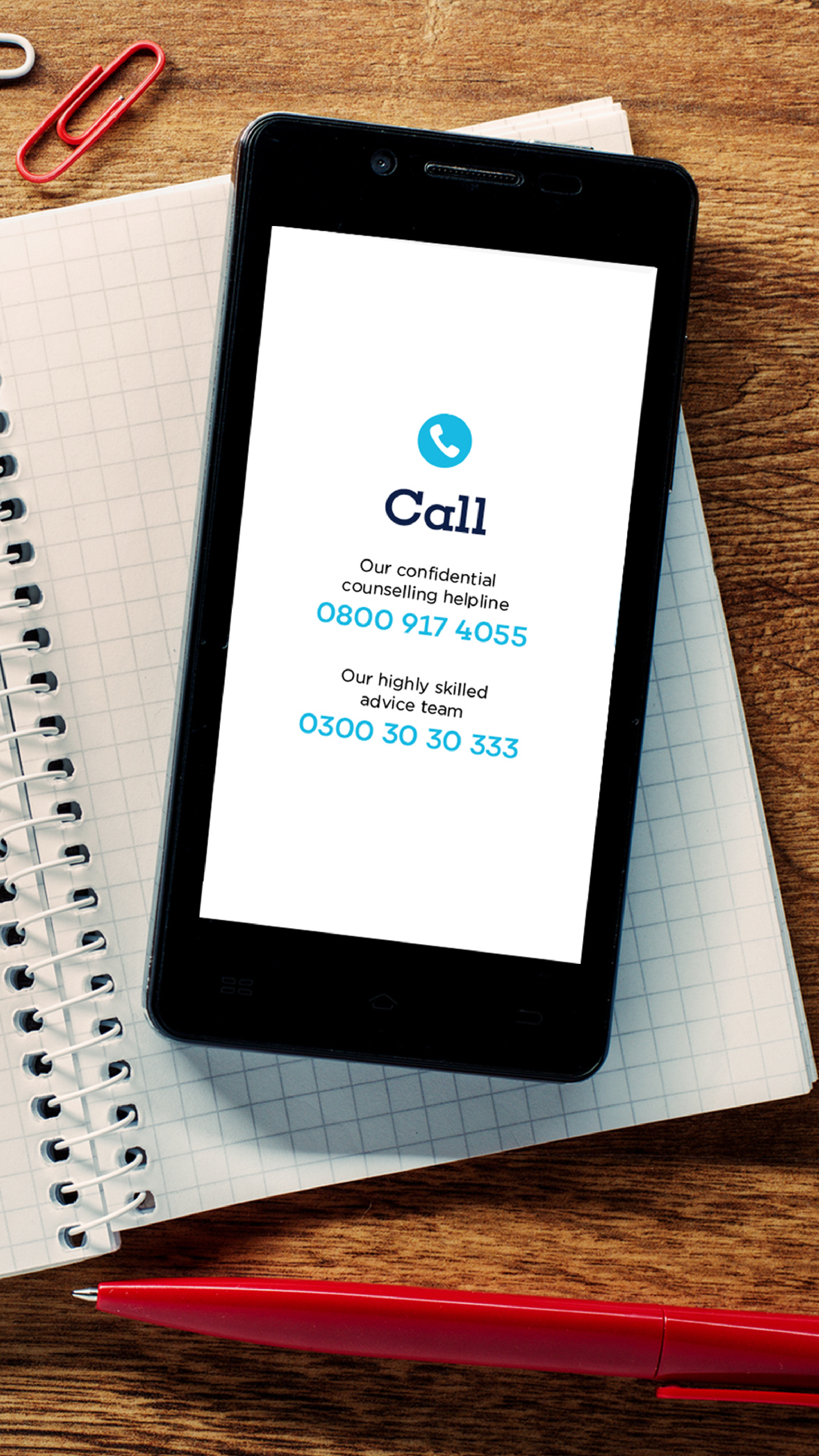 Smartphone on a table displaying advice and support information on the screen.