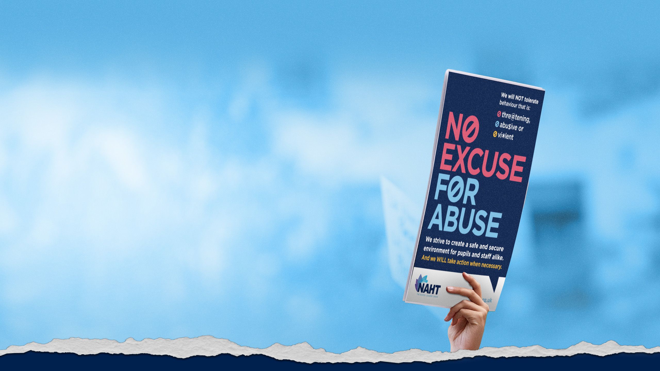 Hand holding a poster that reads ‘No Excuse for Abuse’.
