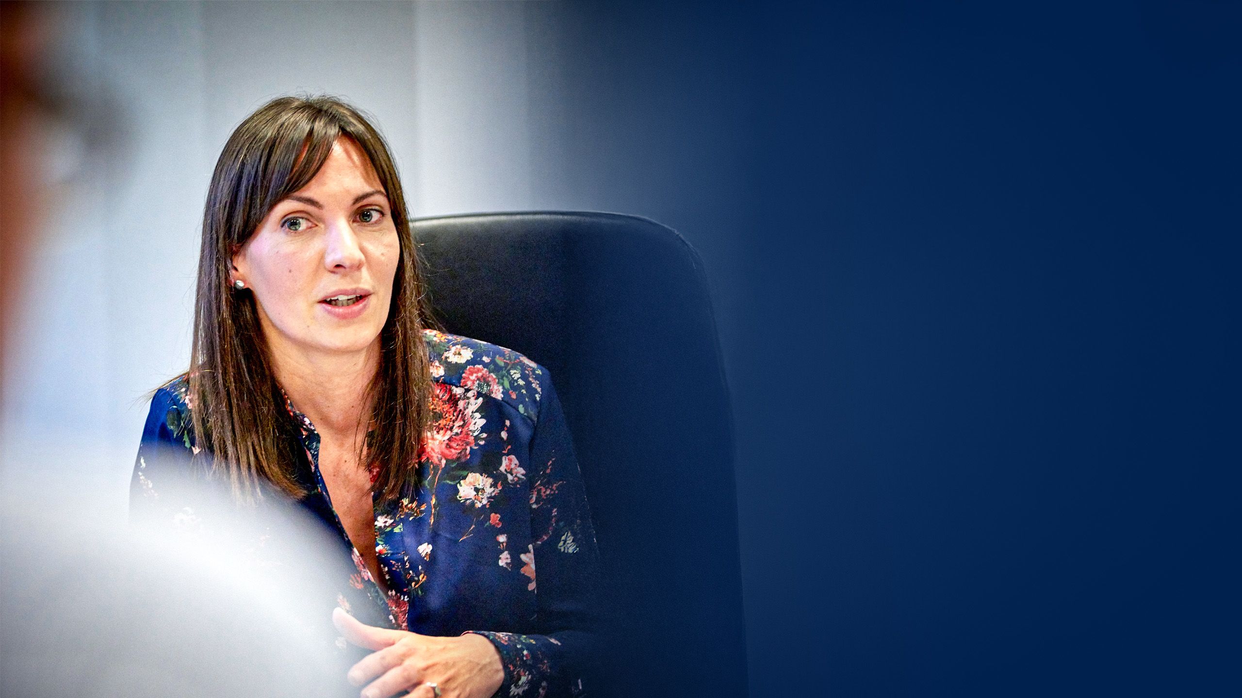 Claire Evans engaged in discussion at a desk.