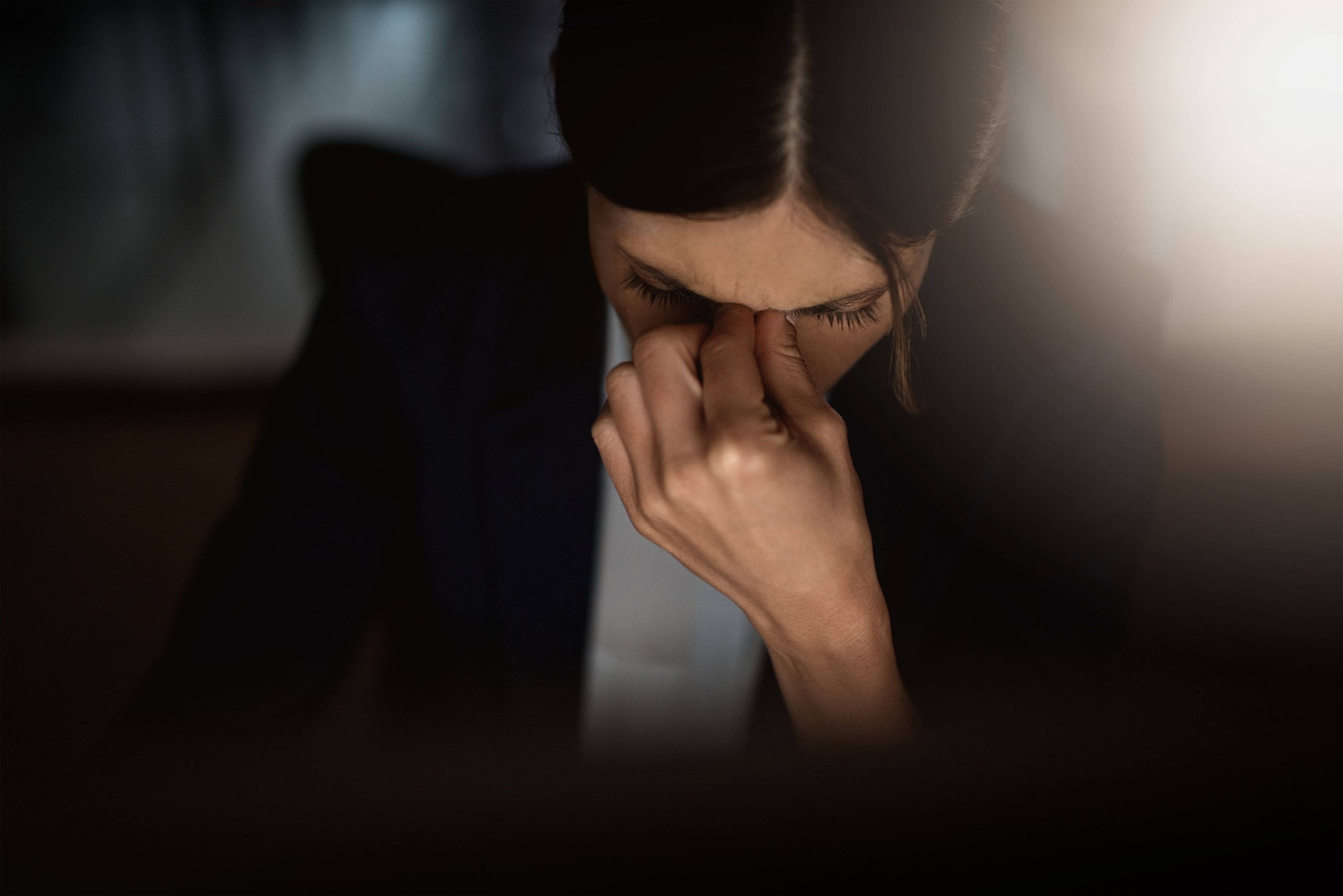 Stressed school leader working late at night, looking tired and overwhelmed in a dark office